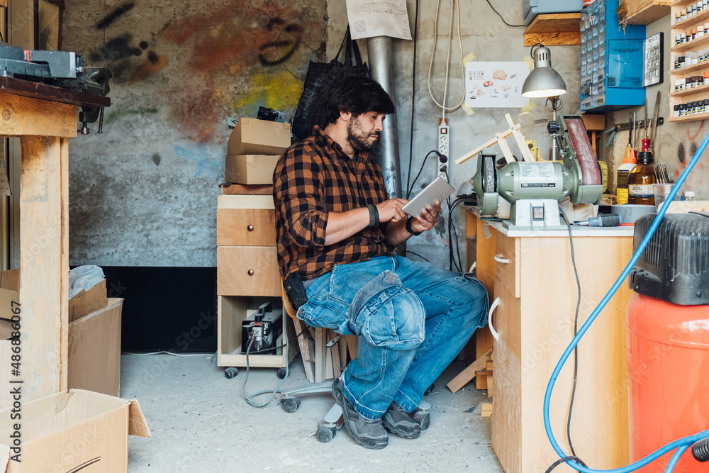 Engineer Using Digital Tablet to Design Robot Arm in his Workshop Engineer Using Digital Tablet to Design Robot Arm in his Workshop