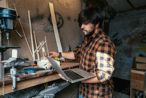 Engineer Using Laptop Computer to Examining Robot Arm