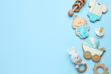 Baby shower cookies and toys on turquoise background, flat lay. Space for text