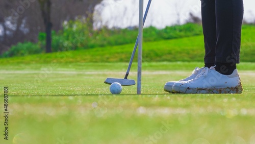 Close-up of a person putting on a golf course. golf training