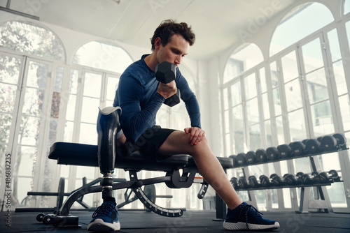 Differently abled athlete doing bicep curls in the gym preparing for the Paralympics photo