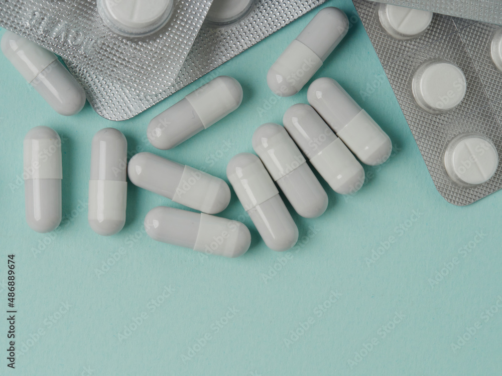 The concept of buying and buying medicines. Various capsules, pills and medicines in a shopping cart on a blue background. A creative idea for a medical, insurance and pharmaceutical company. The concept of buying and buying medicines. Various capsules, pills and medicines in a shopping cart on a blue background. A creative idea for a medical, insurance and pharmaceutical company.