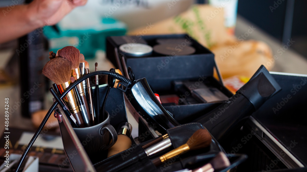 Dedicated focus Make-up converter on makeup artist's table with lots of makeup artist tools. The stack surrounds the makeup artist's table, leaving room for text. Dedicated focus Make-up converter on makeup artist's table with lots of makeup artist tools. The stack surrounds the makeup artist's table, leaving room for text.