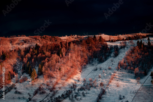 Idylic sunset light over Bucegi Mountains, Romania. Fundata village landscape