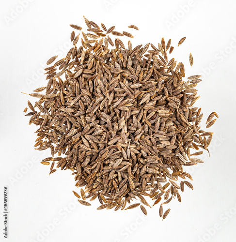 Aroma  spice cumin is scattered on a white isolated background. Top view photo