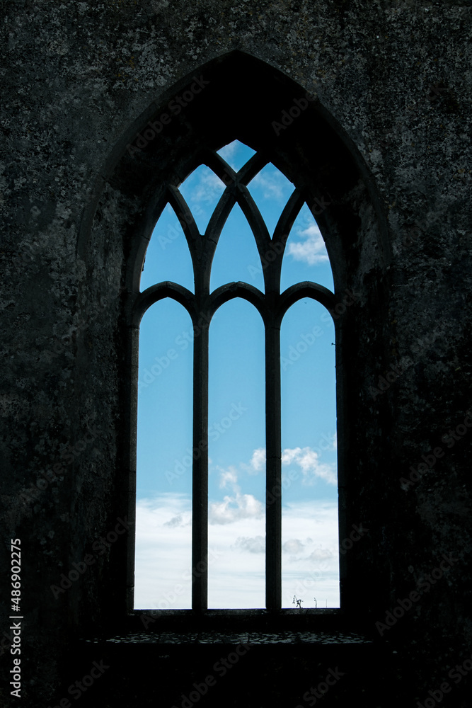 Ein glasloses Fenster in einem alten Kirchengemäuer