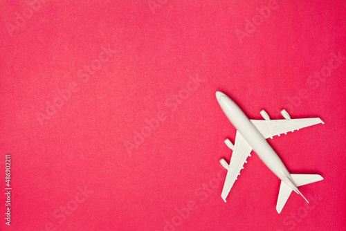 Airplane model. White plane on pink background. Travel vacation concept. Summer background. Flat lay.