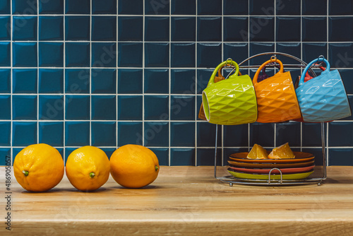three yellow lemons in the kitchen and a tea set