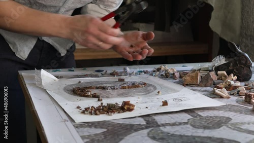 Craftsman cutting smalt glass with nippers cutters for making smalt glass mosaic art