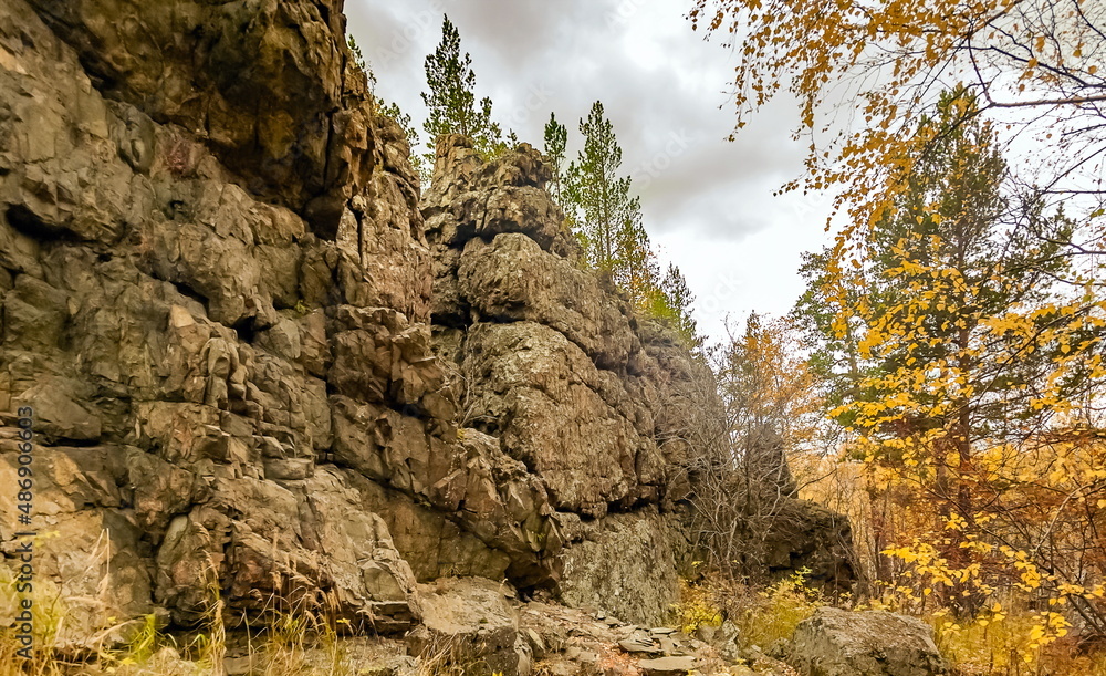 Autumn landscape with rocks, trees and sky with clouds