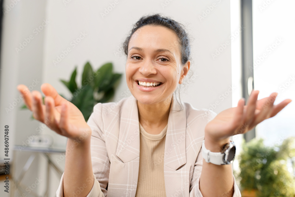 Female colleague in touch. Video chat with middle-aged smiling looks at the camera, talks with customers or colleagues on the distance, female employee involved video meeting Female colleague in touch. Video chat with middle-aged smiling looks at the camera, talks with customers or colleagues on the distance, female employee involved video meeting