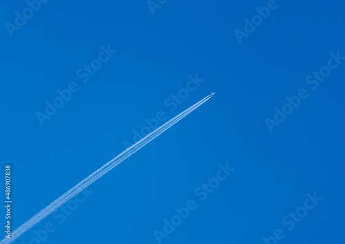A jet forming contrails in a blue sky