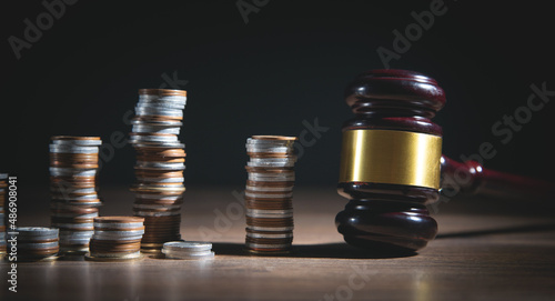 Coins with a wooden judge gavel.