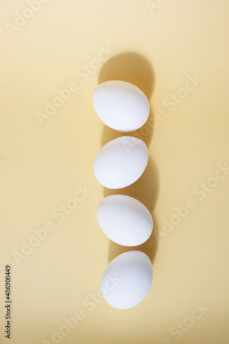 white chicken eggs on a yellow background the concept of Easter in the style of minimalism