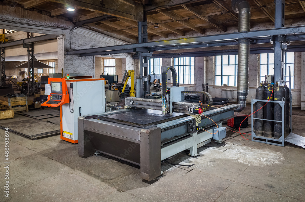 CNC laser cutting machine for sheet metal in the production area. The picture was taken in Russia, in the workshop of a mechanical plant CNC laser cutting machine for sheet metal in the production area. The picture was taken in Russia, in the workshop of a mechanical plant