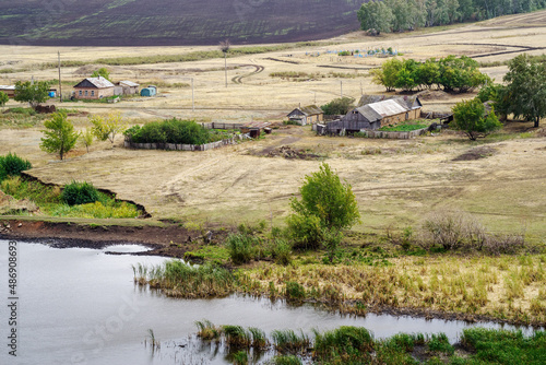 Rural landscape with a village on the banks of a pond and fields. Russia, Orenburg region, farm Arapovka photo