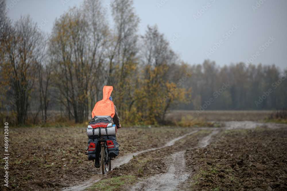 Russian bicyclist on the autumn dirty road, Moscow Region