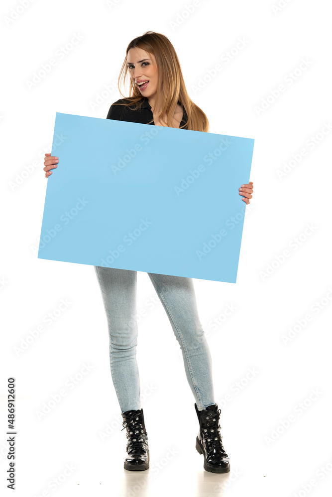 Portrait of attractive young beautiful woman holding blank blue billboard Portrait of attractive young beautiful woman holding blank blue billboard
