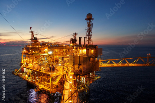 platform for exororation and production oil and gas with bridge in evening time for power energy of the wolrd concept photo