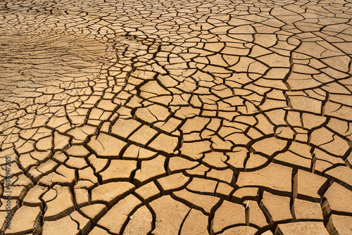 Dry sand or desert ground with cracked surface, Arid environmental global warming disaster. Nature background and texture photo.