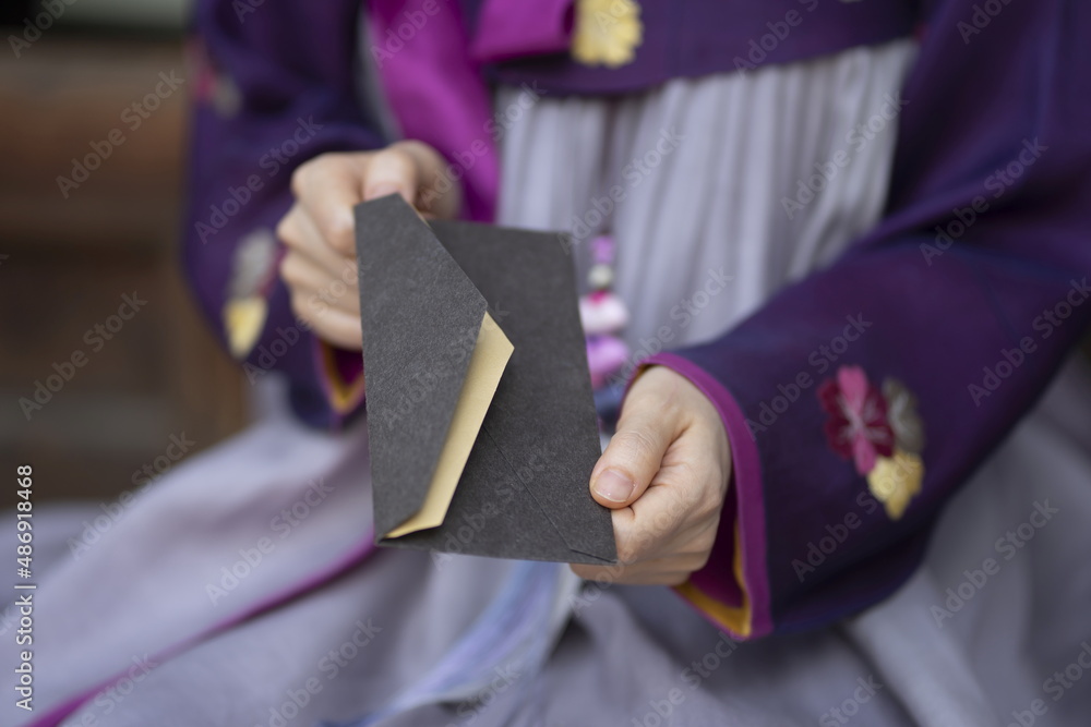 Woman in Korean traditional clothes holding gift voucher