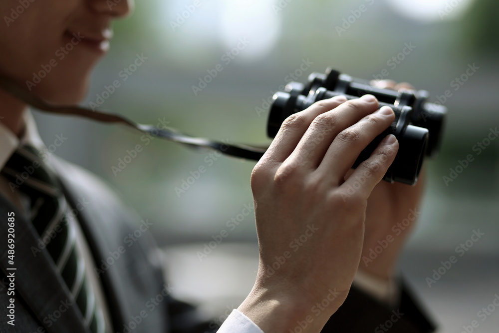 Close up of businessman holding binoculars