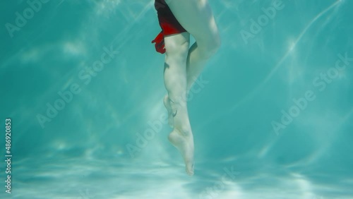 Wallpaper Mural Underwater shot of woman dancing in red chiffon costume. Female dancer moves legs in blue water column with glare. Contemporary ballet underwater. Woman subaquatic shot, close up in slow motion. Torontodigital.ca