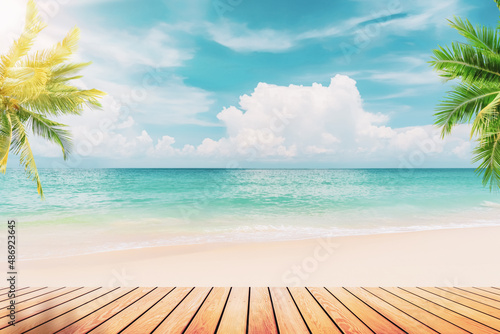 Fototapeta Naklejka Na Ścianę i Meble -  Blur tropical beach with bokeh sun light wave and palm tree on empty old wood table abstract background.