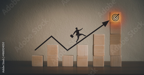 Portrait of a businessman walking on a graph Presentation to reach goals Setting goals for business success by presenting with wooden blocks