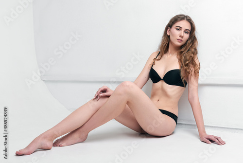 Studio fashion shot: beautiful young girl wearing black lingerie sitting on floor. Model test © jetrel2