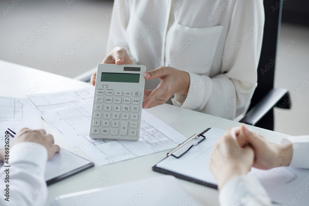 Business people using calculator in meeting Business people using calculator in meeting