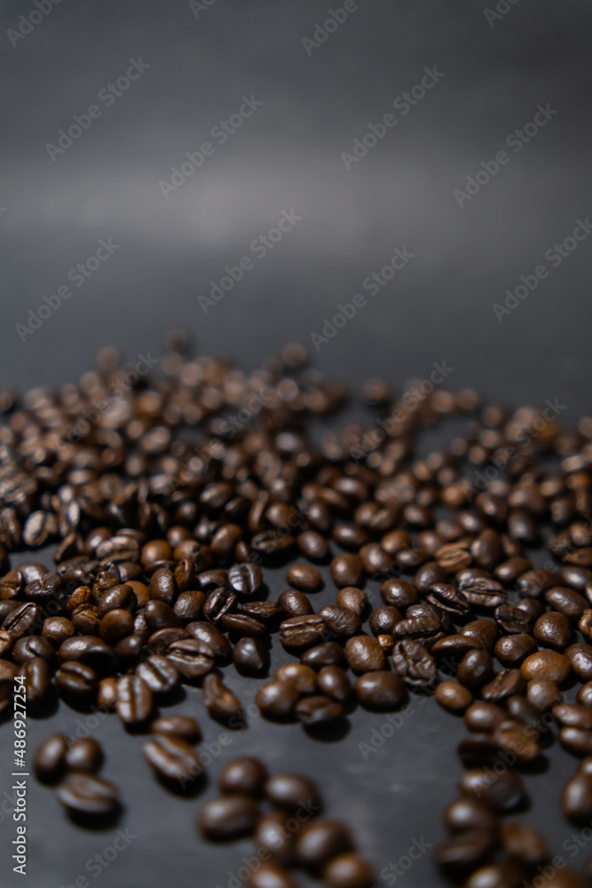 Pile of roasted coffee beans with dark gray background Pile of roasted coffee beans with dark gray background
