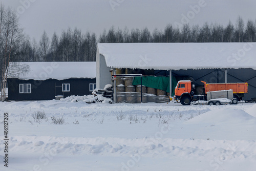 Construction site and heavy truck parking for farm maintenance. Winter landscape