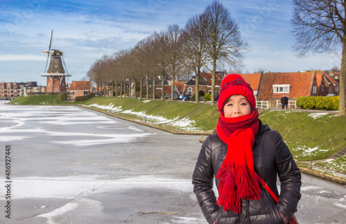 Asian woman in winter coat at the frozen canal of Dokkum photo