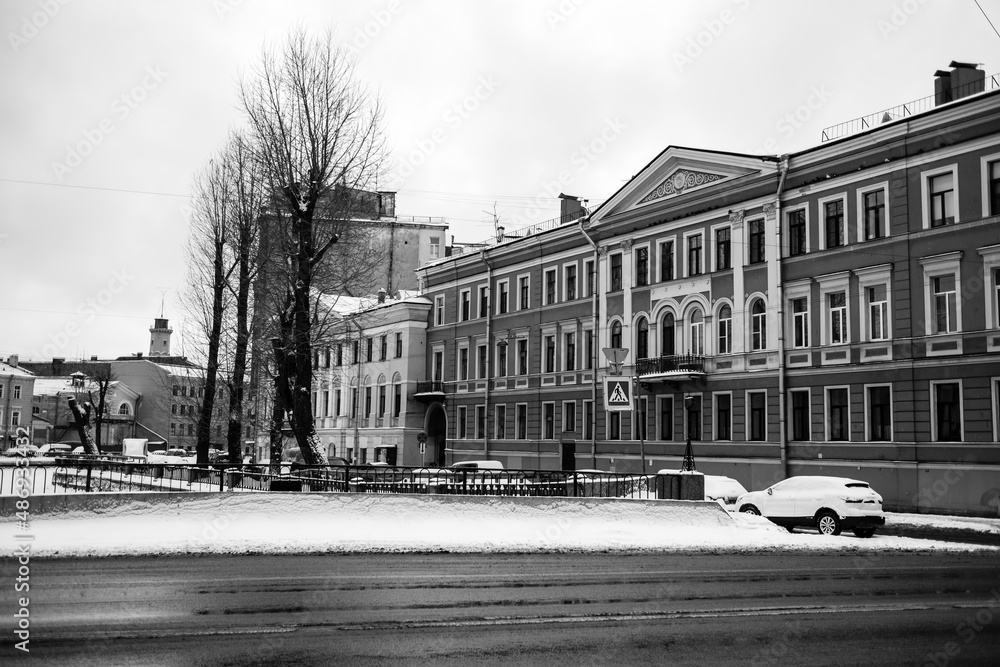 View of Griboyedov Canal embankment buildings in winter, St. Petersburg, Russia. Black and white photograph.