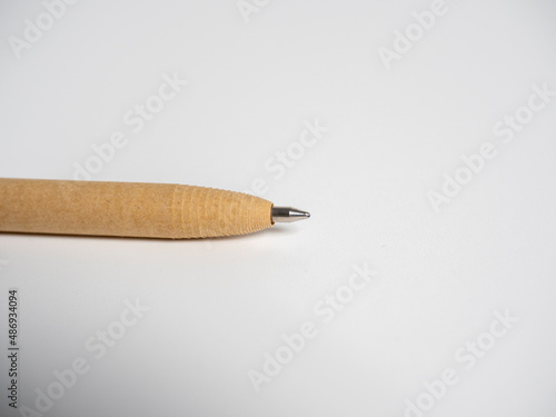Close-up of a pen made of paper on a gray background. Environmental items, the concept of waste recycling.