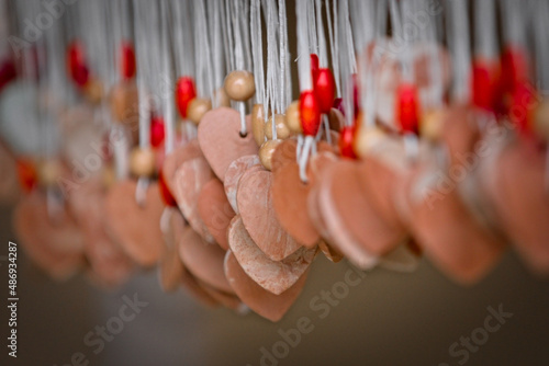 Dozens of hanging Valentine’s pendants, heart-shaped and made of wood, with tiny pearl; choose your one.