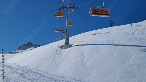 Ski lift in a ski resort in the german alps. Skiers on a ski slope on a sunny winter day.