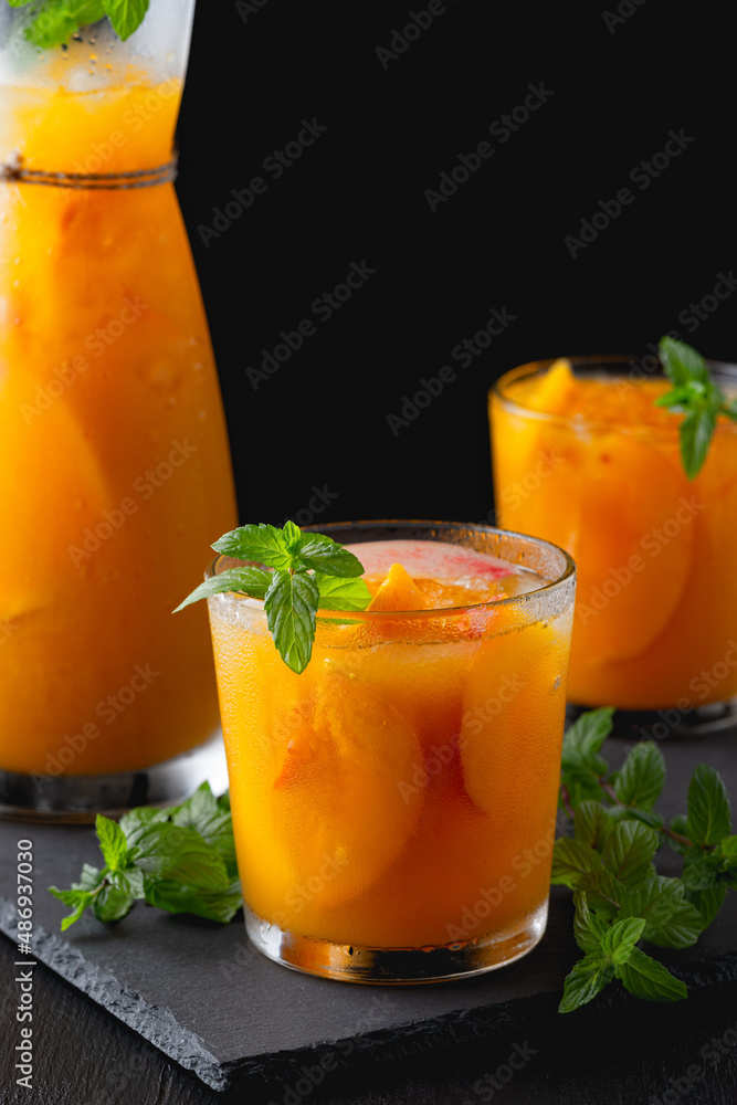 Peach lemonade, cocktail on a black table background. Summer drink Peach lemonade, cocktail on a black table background. Summer drink