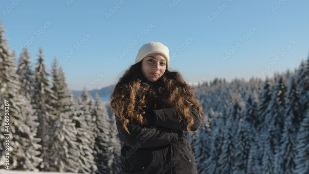 Young Woman Portrait on a Sunny Winter Day, Looking at Camera and Smiling, Having Fun in Winter Days in the Mountains with Snowy Forest in the Background, Slow Motion, 4k, Close Up, Real People Young Woman Portrait on a Sunny Winter Day, Looking at Camera and Smiling, Having Fun in Winter Days in the Mountains with Snowy Forest in the Background, Slow Motion, 4k, Close Up, Real People