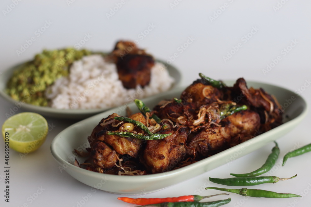 Spicy chicken fry garnished with caramelised onions, served as side dish of kerala rice meal Spicy chicken fry garnished with caramelised onions, served as side dish of kerala rice meal