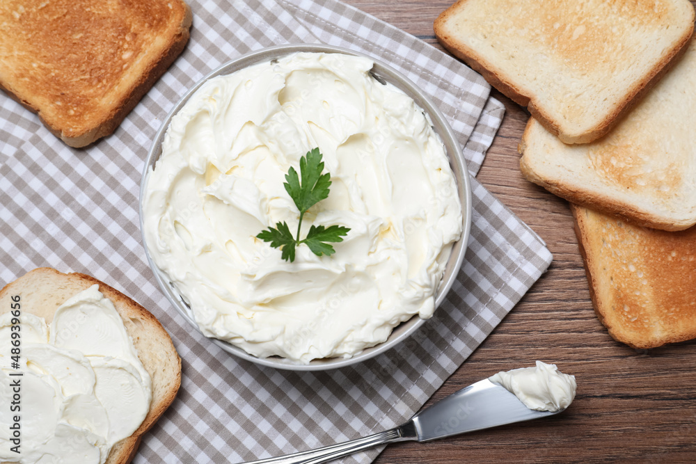 Toasted bread and delicious cream cheese with parsley on wooden table, flat lay Toasted bread and delicious cream cheese with parsley on wooden table, flat lay