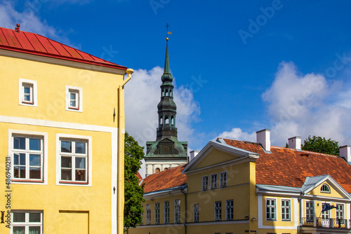 Church tower and yellow buildings in old town of Tallinn Estonia during summer