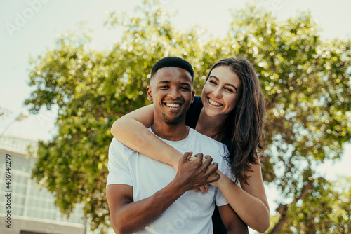 Portrait of biracial couple hugging in the park
