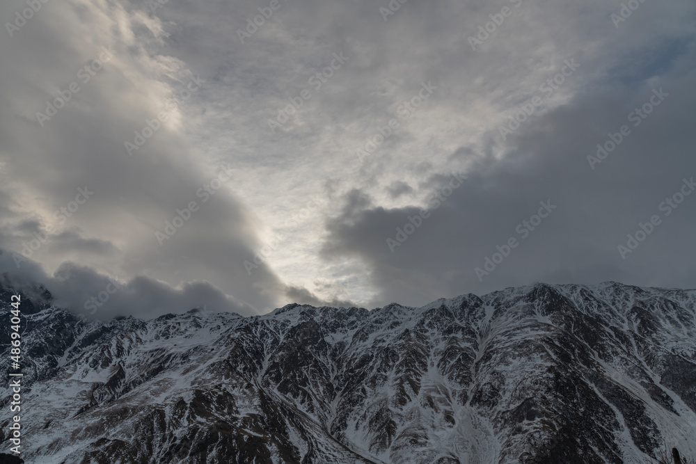Beautiful winter mountains landscape High snow covered mountains in the clouds. Georgia, Kazbegi. Beautiful winter mountains landscape High snow covered mountains in the clouds. Georgia, Kazbegi.