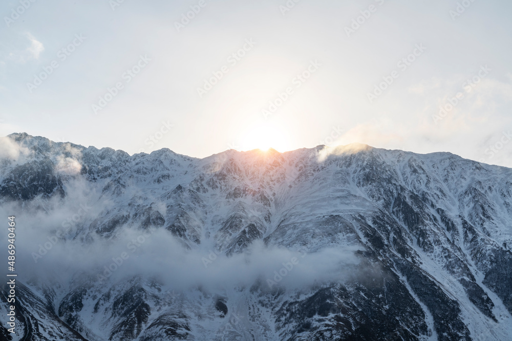 Beautiful winter mountains landscape on the sunset High snow covered mountains in the clouds. Georgia, Kazbegi. Beautiful winter mountains landscape on the sunset High snow covered mountains in the clouds. Georgia, Kazbegi.
