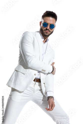 cool bearded businessman with sunglasses holding arms in a fashion pose © Viorel Sima