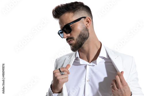 seductive young businessman with sunglasses opening suit