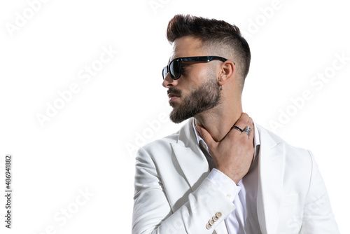 handsome unshaved businessman with glasses holding hand on neck
