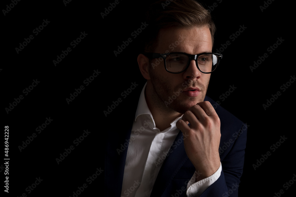 portrait of attractive businessman with glasses looking to side and thinking portrait of attractive businessman with glasses looking to side and thinking